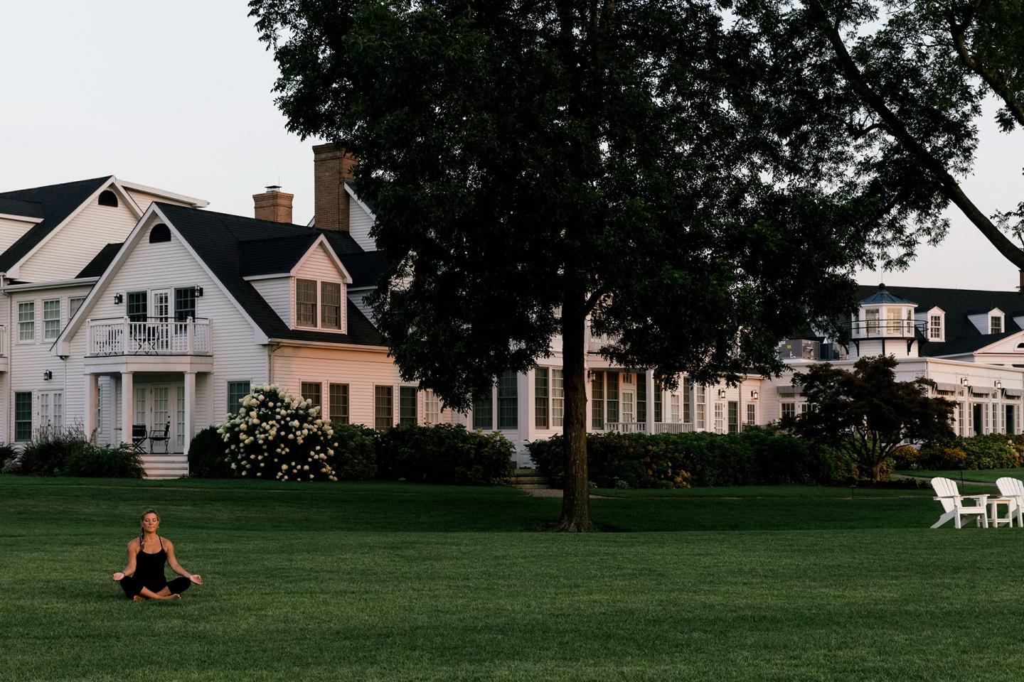 Women in a meditation pose on the grass