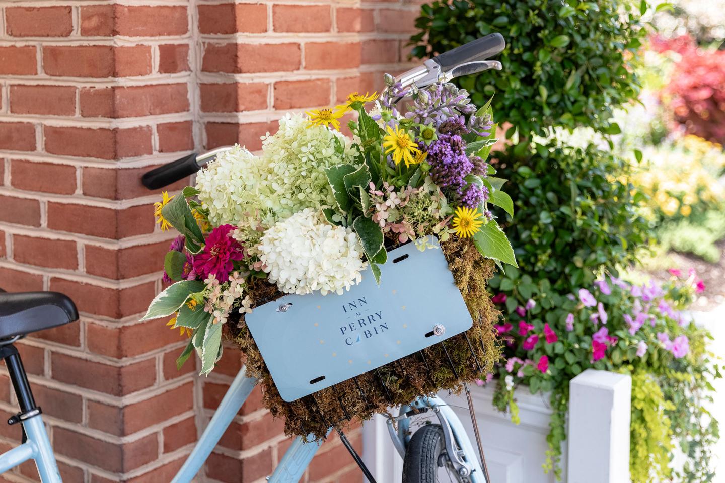 Flowers in a basket on the front of a bike