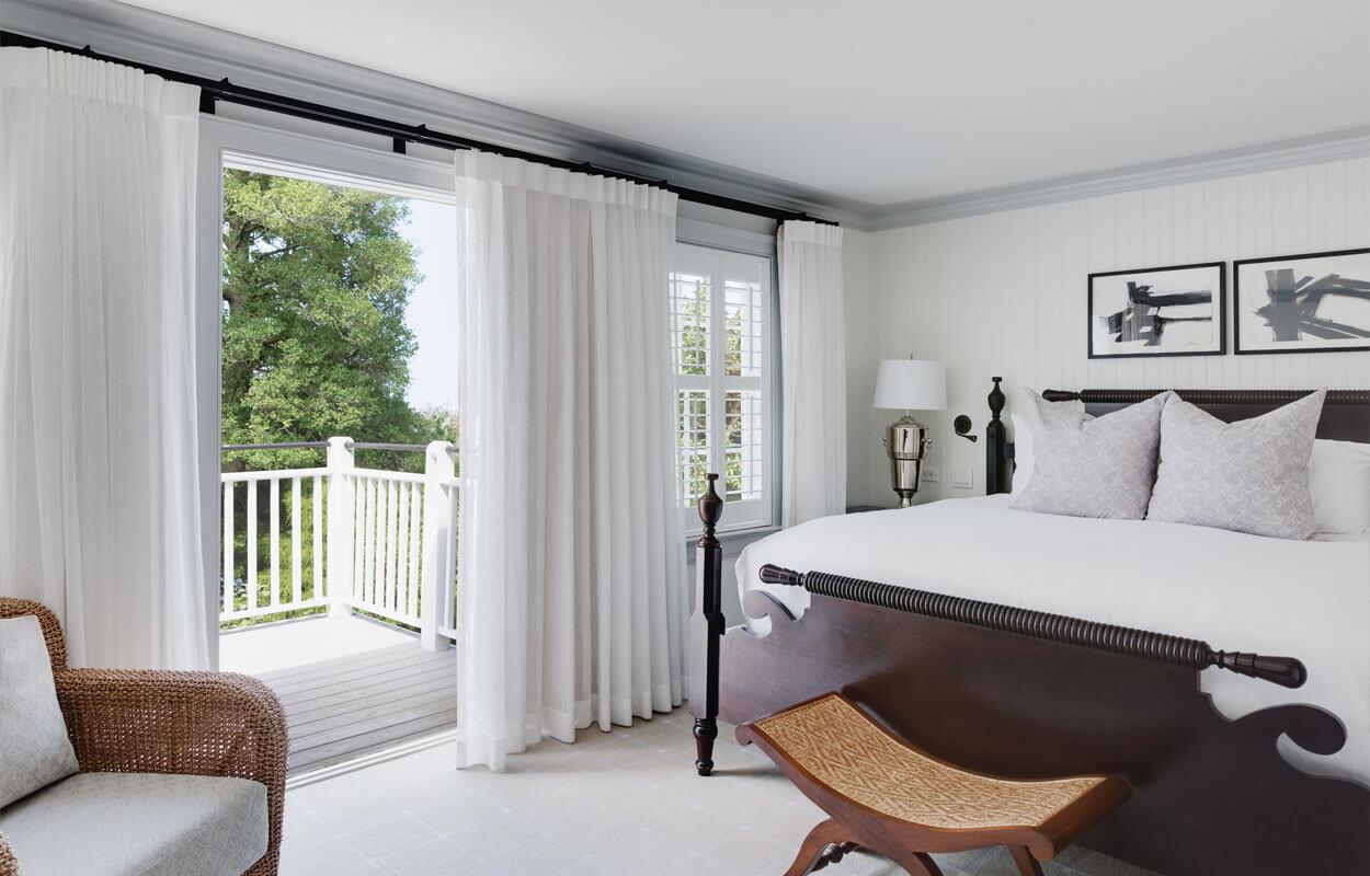 Guestroom setting with bed and balcony at Inn at Perry Cabin