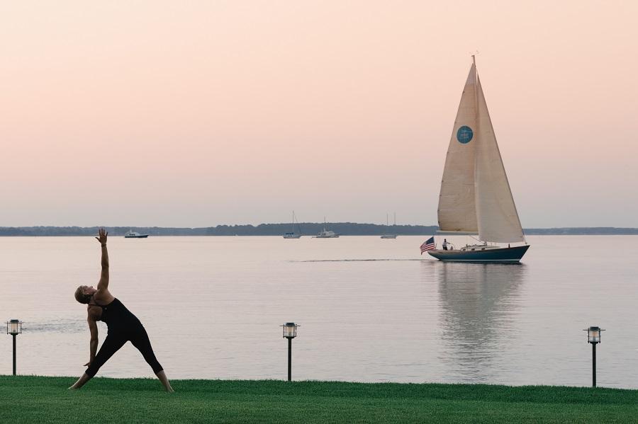 Women practising yoga by the water