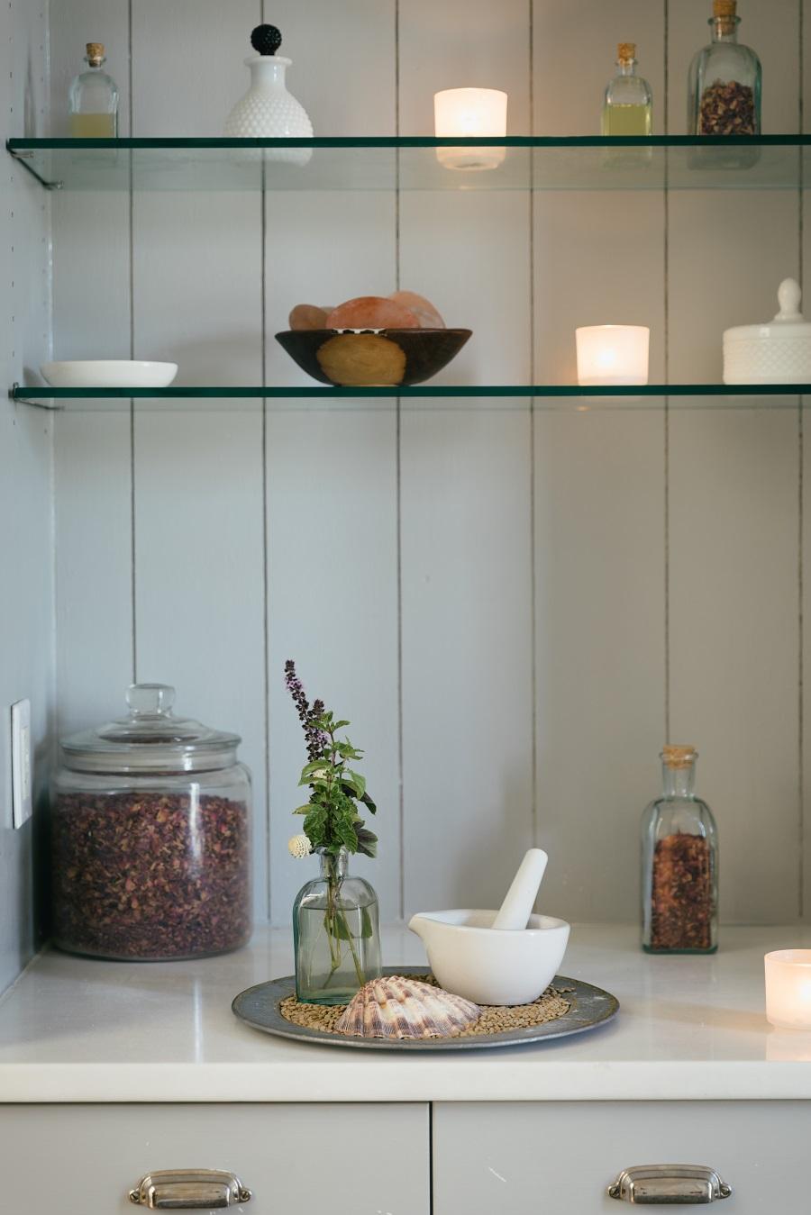 Candles and herbs on shelving in Spa