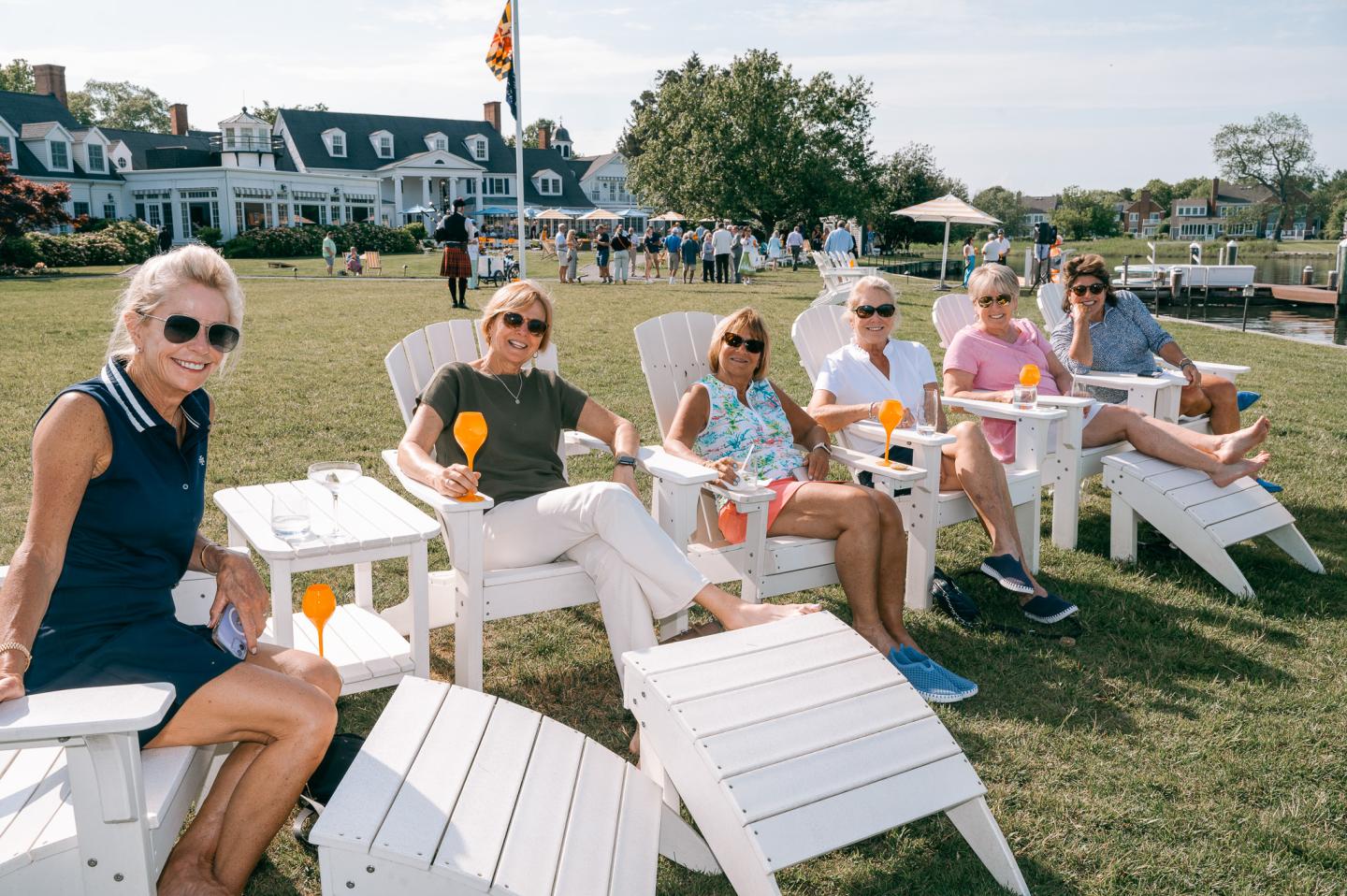 Happy Guests at Event with drinks sitting in adirondack chairs