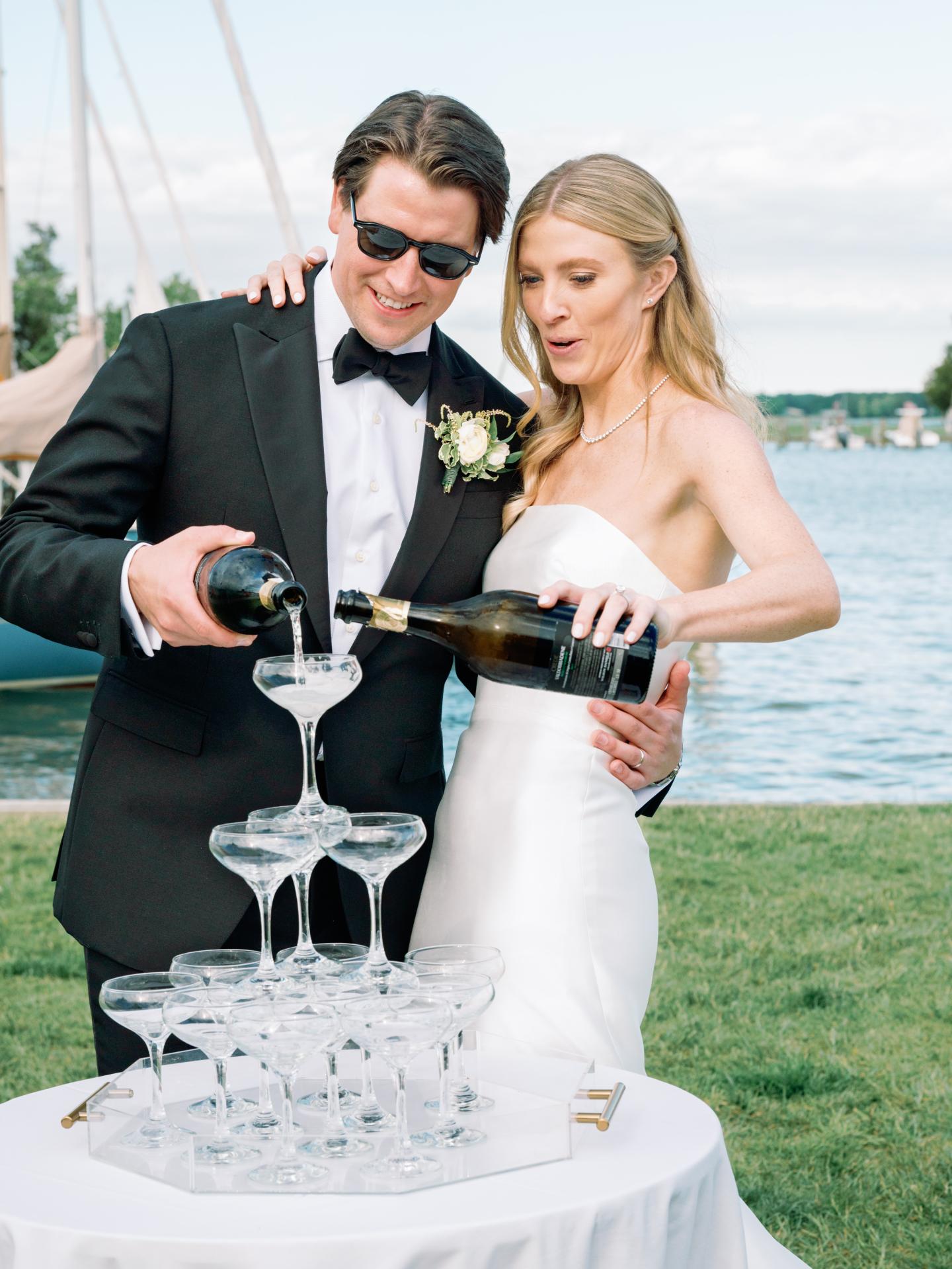 Bride and Groom filling champagne tour in front of dock
