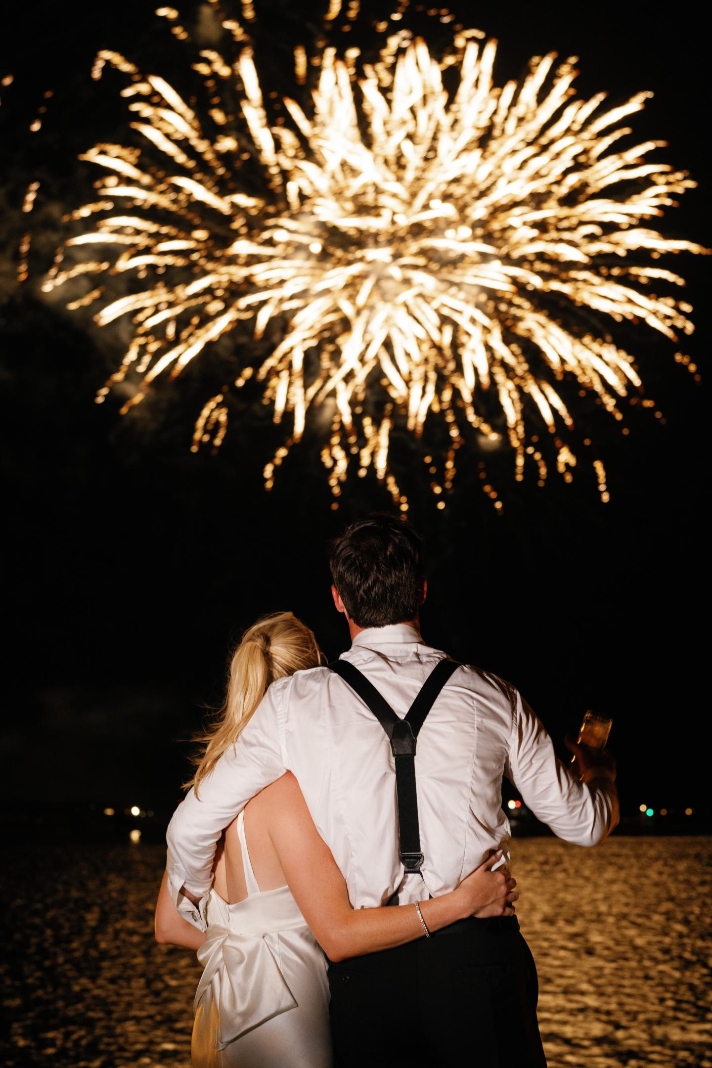 Bride and groom watching fireworks over the Miles River during their reception