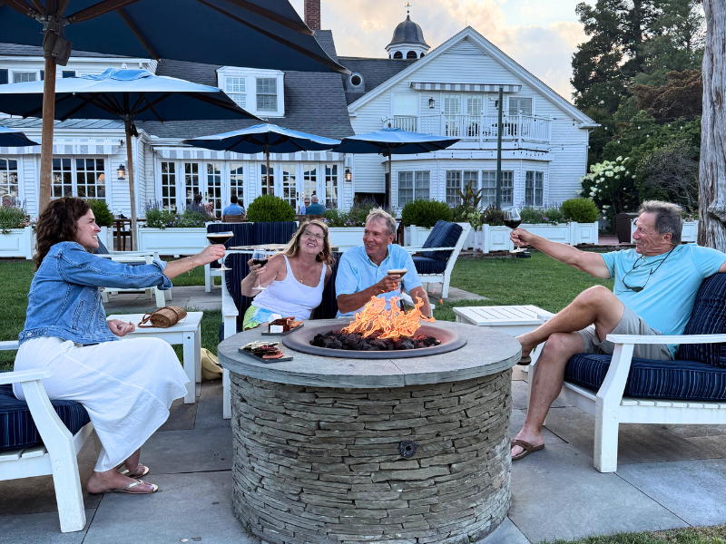 Guests enjoying an evening around waterfront firepits