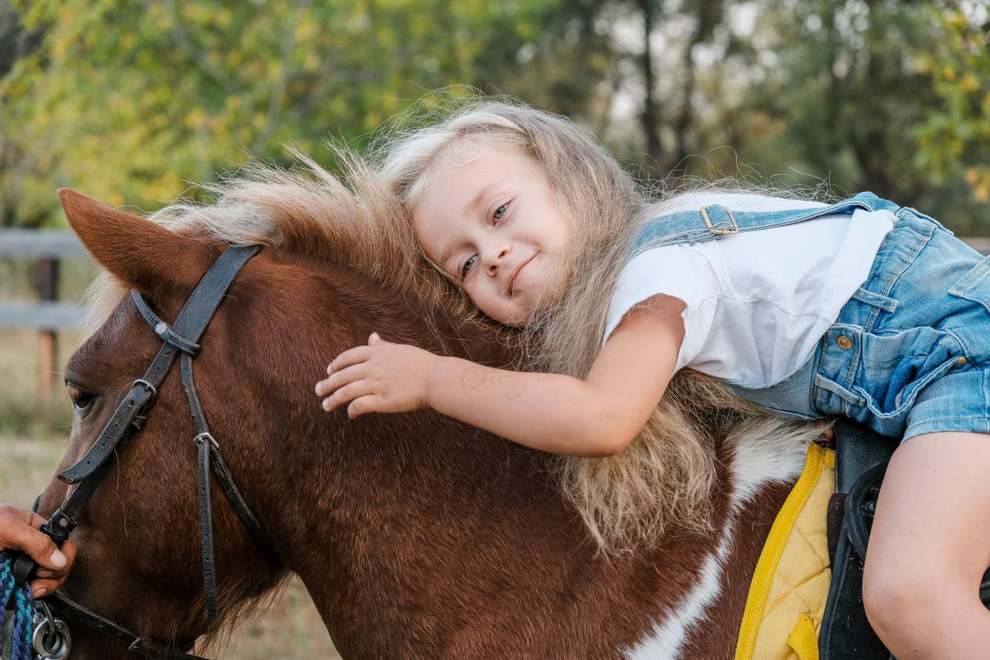Child hugging pony during pony ride